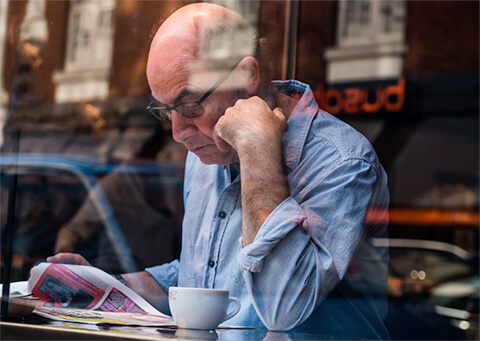 Older man reading in cafe